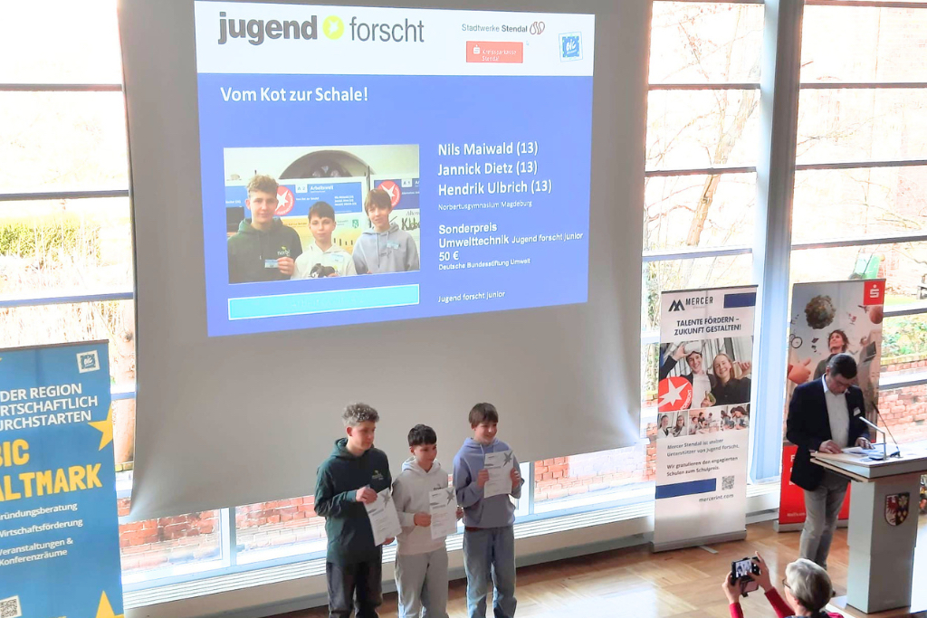 Drei Schüler des Norbertusgymnasiums stehen auf der Bühne und werden mit dem Sonderpreis Umwelttechnik des "Jugend forscht" - Landeswettbewerbes Sachsen-Anhalt geehrt